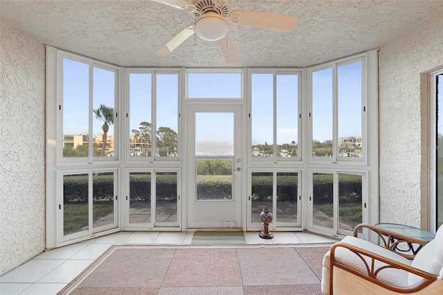 unfurnished sunroom featuring ceiling fan