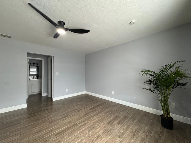 unfurnished room featuring ceiling fan, dark hardwood / wood-style floors, and a textured ceiling