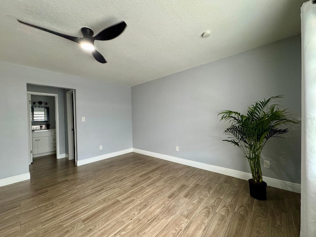 unfurnished room with ceiling fan, hardwood / wood-style floors, and a textured ceiling