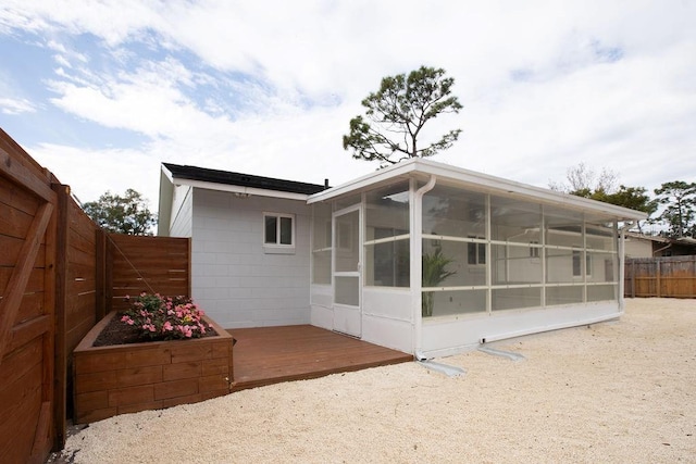 back of house featuring a deck and a sunroom