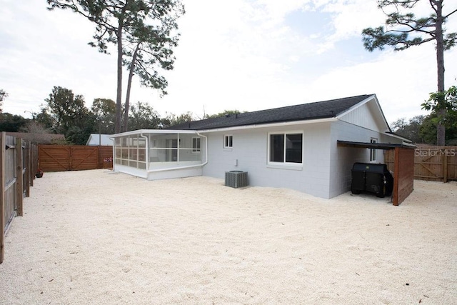 rear view of property featuring central AC and a sunroom