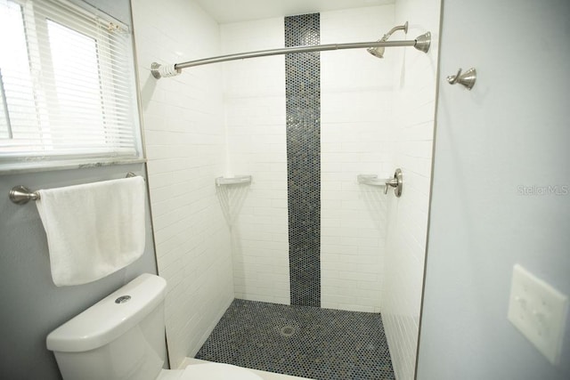 bathroom with toilet and a tile shower