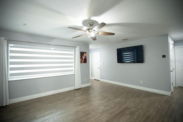 spare room with ceiling fan, dark wood-type flooring, and a textured ceiling