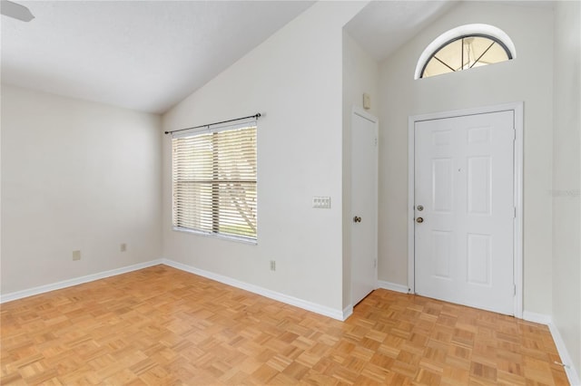 foyer entrance featuring high vaulted ceiling and light parquet flooring