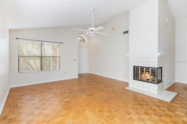 unfurnished living room featuring a tile fireplace, light parquet flooring, ceiling fan, and high vaulted ceiling