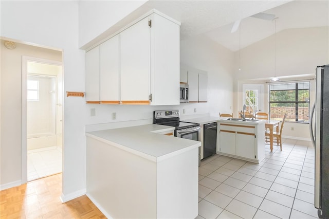 kitchen with high vaulted ceiling, stainless steel appliances, kitchen peninsula, and white cabinets