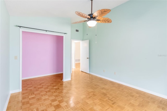 empty room featuring ceiling fan, light parquet flooring, and high vaulted ceiling