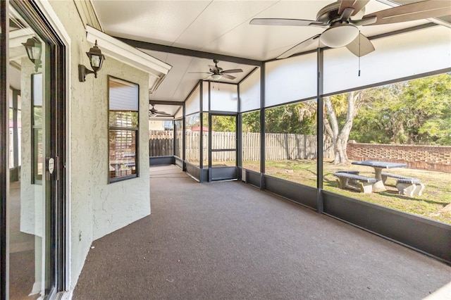 unfurnished sunroom featuring ceiling fan