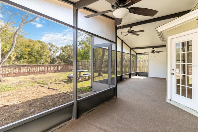 unfurnished sunroom featuring lofted ceiling with beams