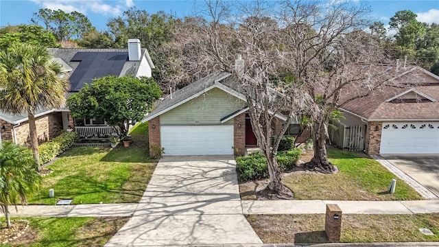 view of front of home with a garage, a front yard, and solar panels