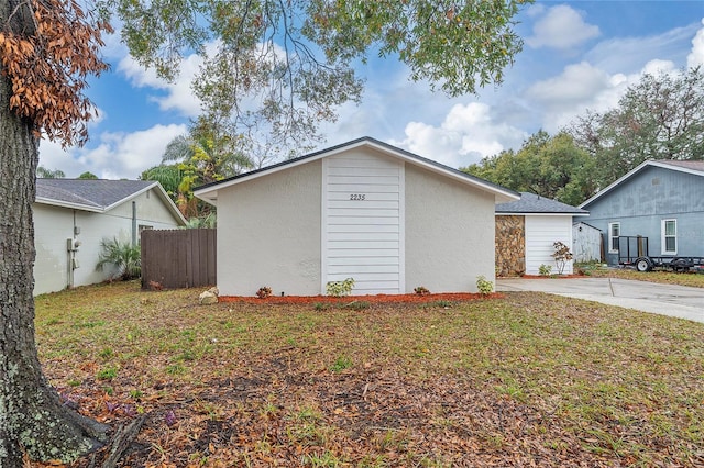 view of side of home with an outdoor structure and a yard