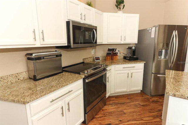 kitchen featuring stainless steel appliances, white cabinetry, light stone countertops, and dark hardwood / wood-style flooring