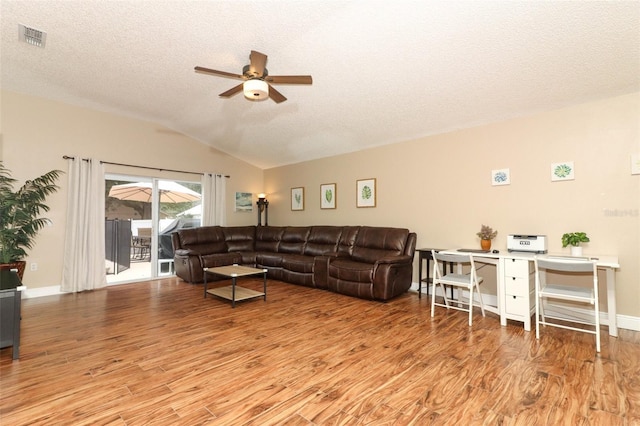 living room with ceiling fan, vaulted ceiling, light hardwood / wood-style floors, and a textured ceiling