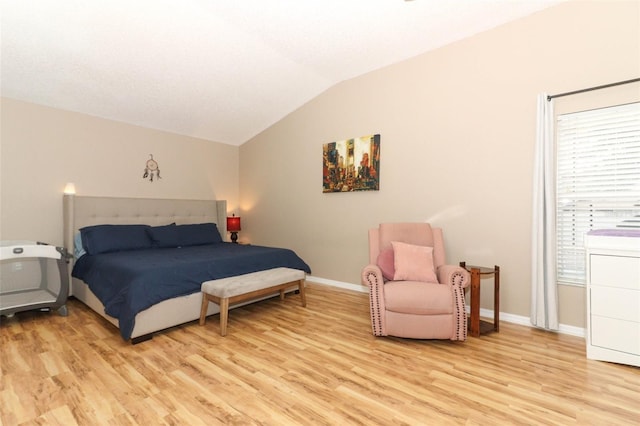 bedroom with vaulted ceiling and light hardwood / wood-style flooring