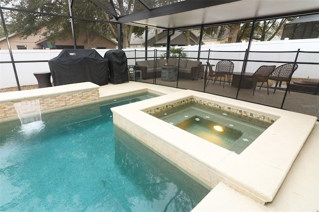 view of swimming pool with an in ground hot tub, glass enclosure, grilling area, and a patio