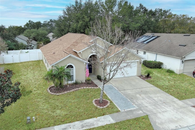 ranch-style home with a garage and a front yard