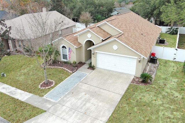 view of front of home with a garage, central AC, and a front lawn