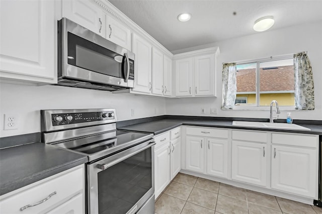 kitchen with sink, light tile patterned flooring, white cabinetry, and appliances with stainless steel finishes