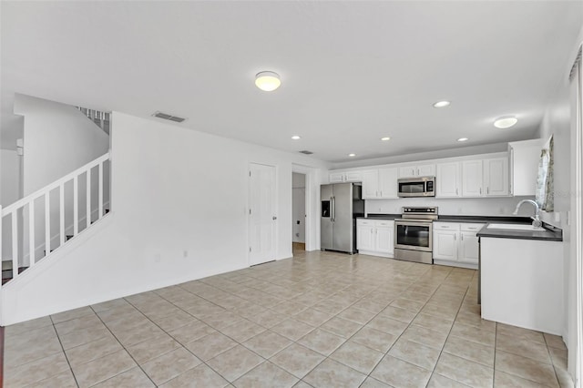 kitchen featuring white cabinets, light tile patterned floors, appliances with stainless steel finishes, and sink