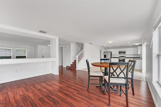 dining room featuring sink and dark wood-type flooring