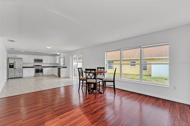 dining area with light hardwood / wood-style floors and a wealth of natural light