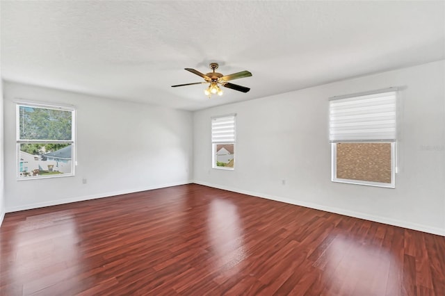 empty room featuring ceiling fan and dark hardwood / wood-style flooring