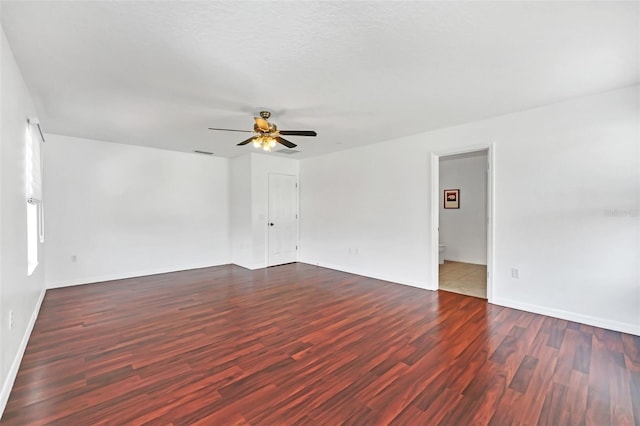 spare room with ceiling fan, dark wood-type flooring, and a textured ceiling