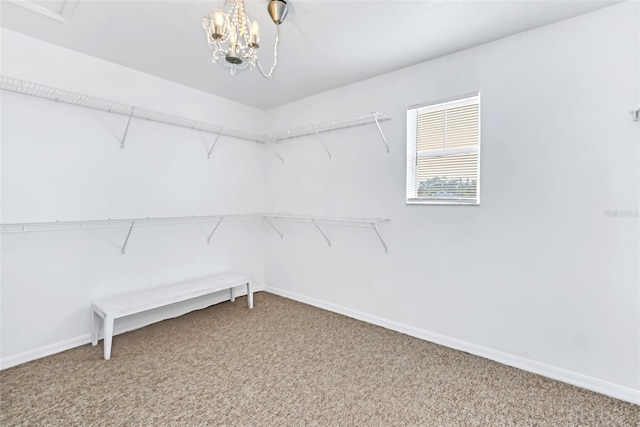 spacious closet with carpet floors and a notable chandelier