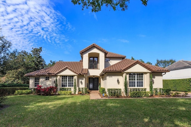 mediterranean / spanish house featuring a front yard