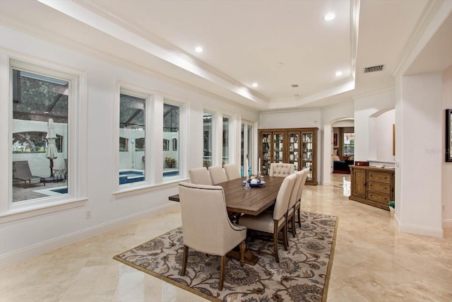 dining area featuring crown molding, a healthy amount of sunlight, and a tray ceiling