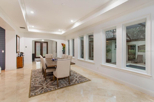 dining area with french doors and a raised ceiling