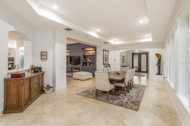 dining space with french doors, sink, built in features, a tray ceiling, and crown molding