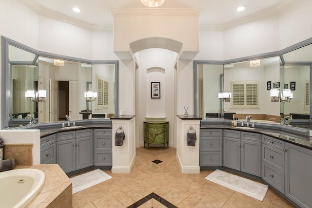 bathroom featuring vanity, tiled tub, ornamental molding, and tile patterned flooring