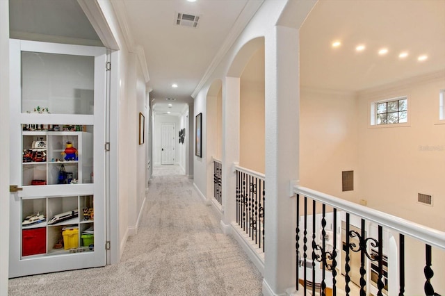 hallway featuring light colored carpet and ornamental molding