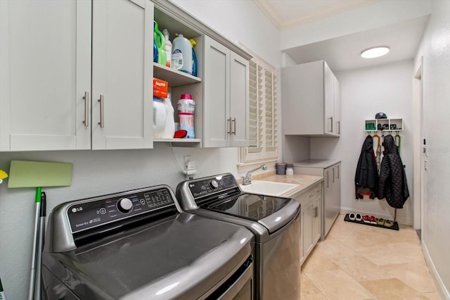 clothes washing area featuring sink, cabinets, washing machine and dryer, and ornamental molding