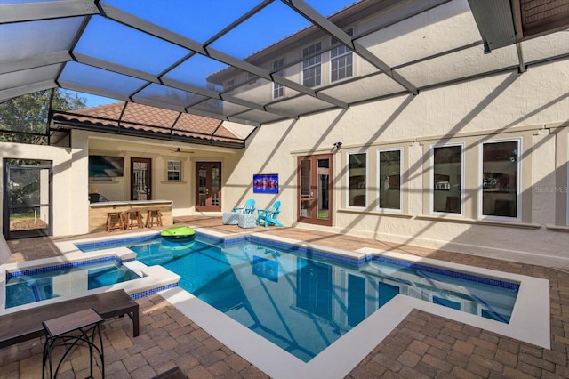 view of swimming pool featuring an outdoor bar, ceiling fan, an in ground hot tub, a lanai, and a patio area