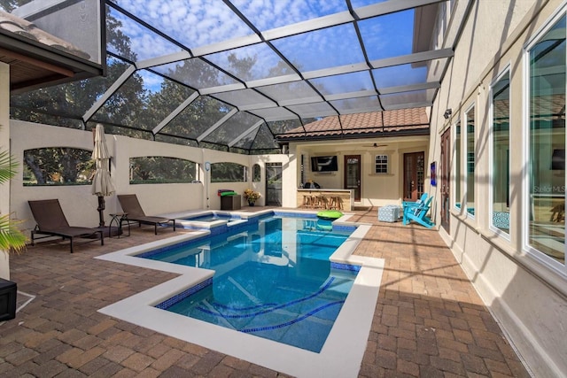 view of swimming pool with an in ground hot tub, a patio, a lanai, and a bar