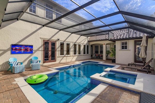 view of pool with an in ground hot tub, a patio area, glass enclosure, and french doors