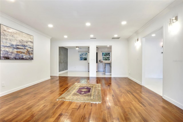 interior space with crown molding, wood-type flooring, and ceiling fan