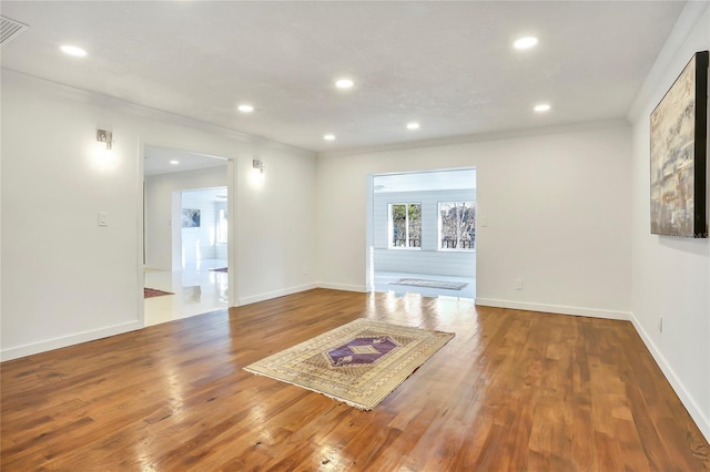 unfurnished living room featuring hardwood / wood-style flooring and ornamental molding