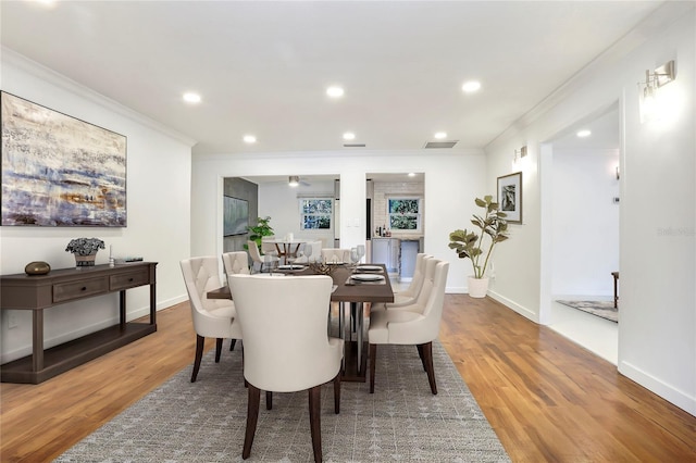 dining room featuring hardwood / wood-style flooring and crown molding