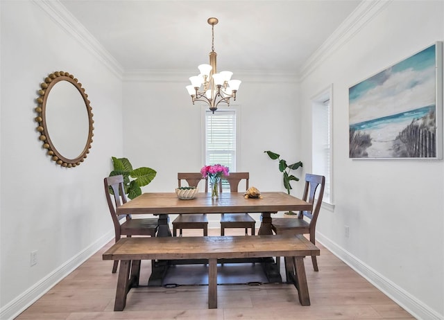 dining area featuring crown molding, light hardwood / wood-style floors, and a chandelier