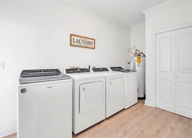 laundry area featuring washing machine and dryer, ornamental molding, light hardwood / wood-style floors, and water heater