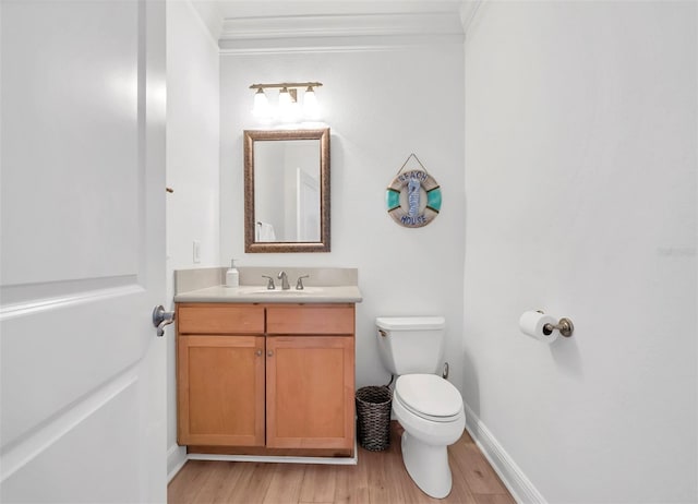 bathroom featuring ornamental molding, hardwood / wood-style floors, toilet, and vanity