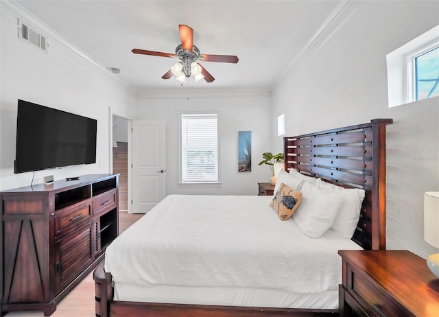 bedroom featuring multiple windows, ceiling fan, and ornamental molding