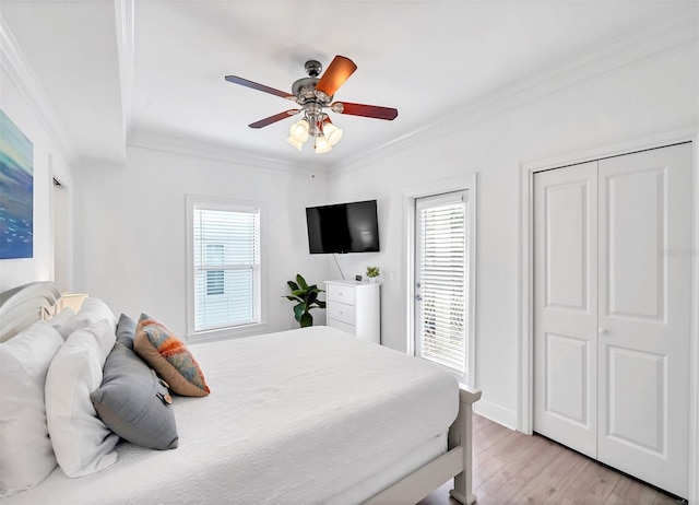 bedroom with ceiling fan, multiple windows, light hardwood / wood-style flooring, and ornamental molding