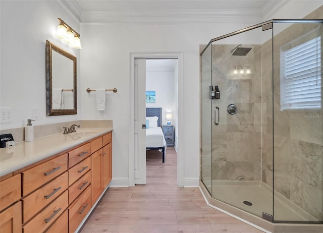 bathroom featuring a shower with shower door, vanity, and ornamental molding