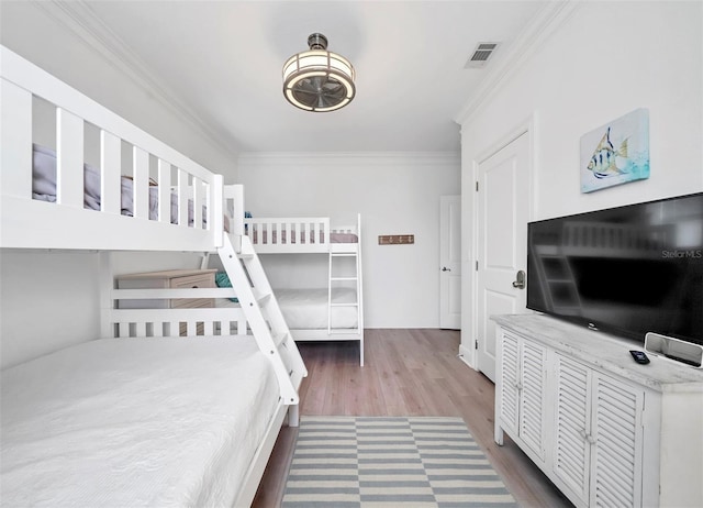 bedroom with hardwood / wood-style flooring and ornamental molding