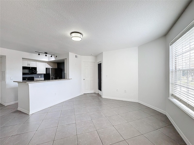 kitchen with light tile patterned flooring, rail lighting, black appliances, kitchen peninsula, and white cabinets