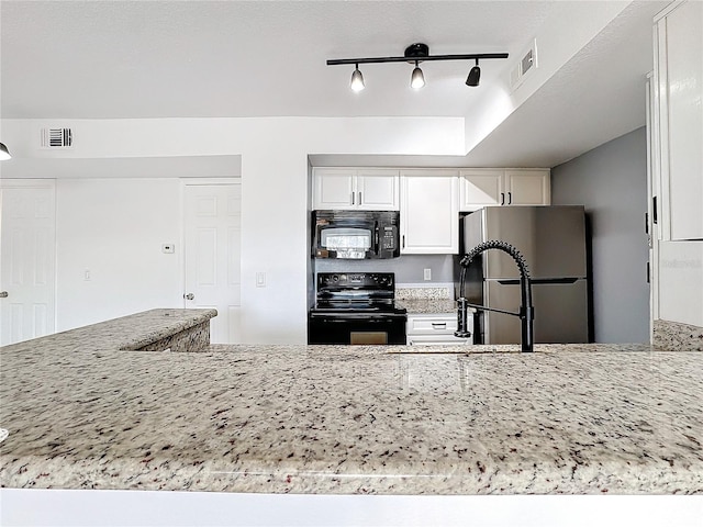 kitchen with light stone counters, white cabinetry, and black appliances